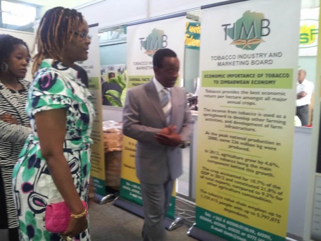 Timb chief executive Dr Andrew Matibiri explaining on tobacco production at the Timb stand while Amai Grace Mugabe looks on