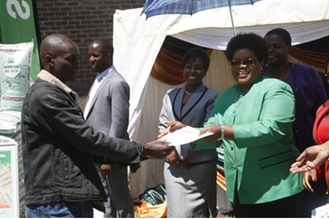 Vice President Joice Mujuru hands over an award to Tobacco Improved Productivity Sites course participant from Mashonaland Central Mr Suarance Matope in Harare yesterday.