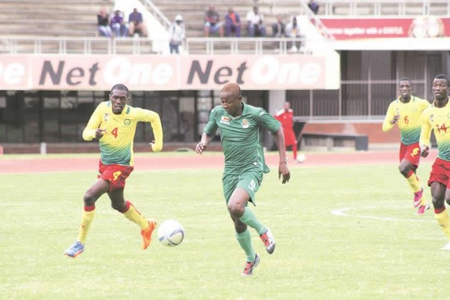EYES ON THE BALL . . . Young Warriors forward Prince Dube (right) charges towards goal under the close attention of Cameroon defender Grace Makani in an Under-20 Africa Cup of the Nations qualifier at the National Sports Stadium yesterday