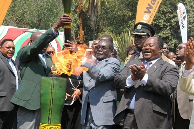 President Mugabe lights the Games torch while then Minister of Sport, Arts and Culture Andrew Langa looks on at State House in Harare, in this file picture