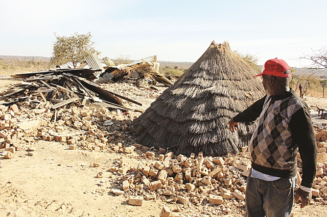 A man points to a demolished homestead at Willsgroove Farm near Bulawayo