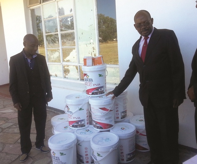 Former Plumtree High student Mr Roy Tapela (left) hands over paint to the school’s headmaster Mr Sipo Kumalo