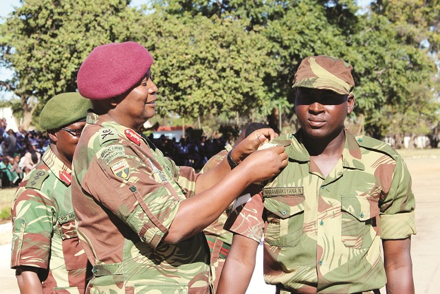 The Chief of Staff Major-General Trust Mugova confers a rank of Lance Corporal to Nomore Marambakuyana of 13 Reserve Force Battalion during a passout parade at Mbalabala last week