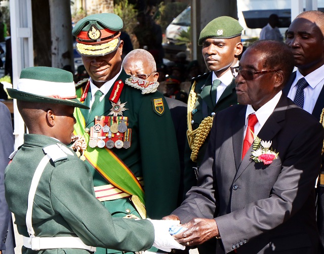 President Mugabe and Commander in Chief of the Zimbabwe Defence Forces yesterday presented a prize to the second best officer cadet Nyasha Kajau during the commissioning parade of officer cadets at the Zimbabwe Military Academy in Gweru.Looking on is the Commander Zimbabwe National Army Lt. Gen. Philip Valerio Sibanda.(Picture by Eliah Saushoma)