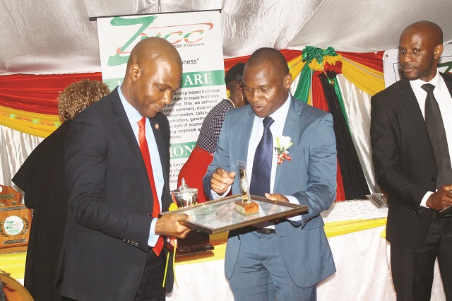 Dr Tinashe Manzungu of the ZNCC Midlands Chapter hands over the Best Financial Services award to Mr Gerald Zhou (left) of Inclusive Financial Services at the ZNCC Midlands Chapter Business Awards ceremony in Gweru last Friday