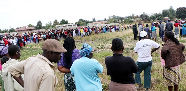 Residents crowd the murder scene of a young woman whose body was dumped on an open space in Pelandaba,Bulawayo yesterday.