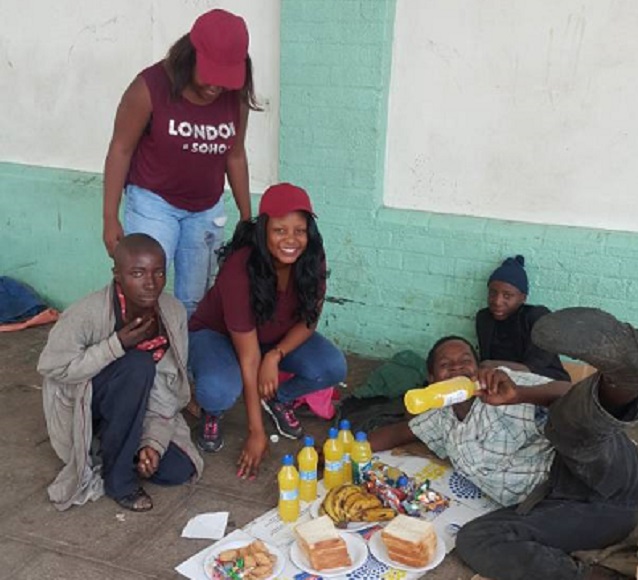 Miss Sithabile Gandi Ndlovu (kneeling) and Miss Nkazimulo Khumalo (standing) drove around the streets of Bulawayo giving food to every homeless person they met from 12 noon to around 7pm.