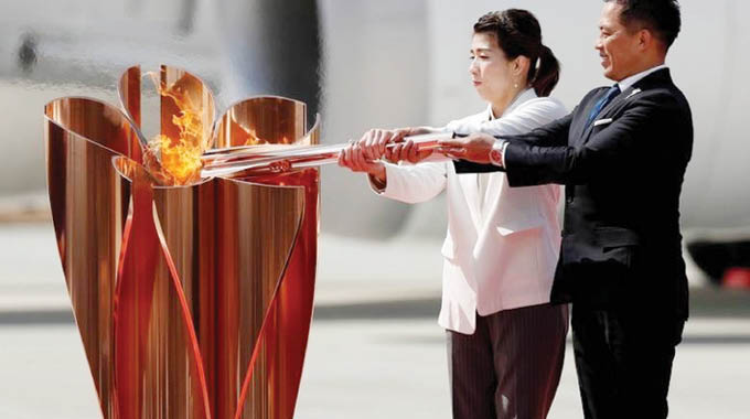 Olympic flame gets muted welcome in Japan as Games doubts grow